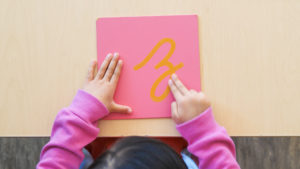 a child traces the letter z with two fingers